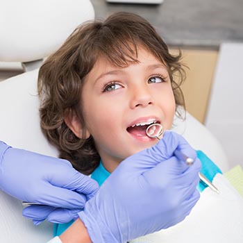 Little boy getting his teeth examined
